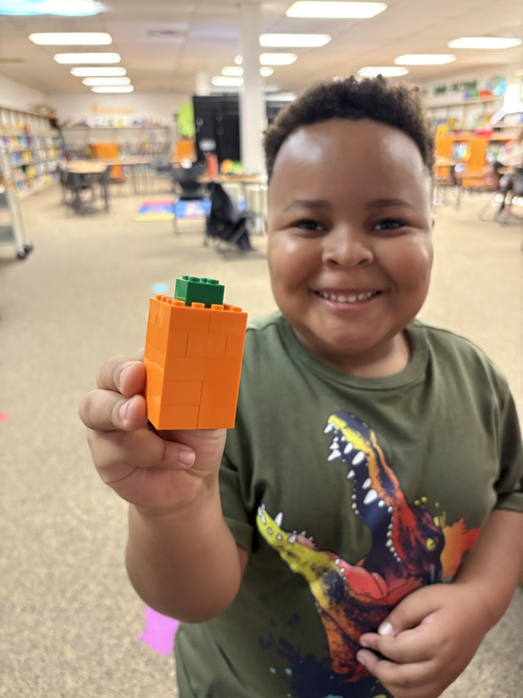 Student holding a Lego pumpkin 