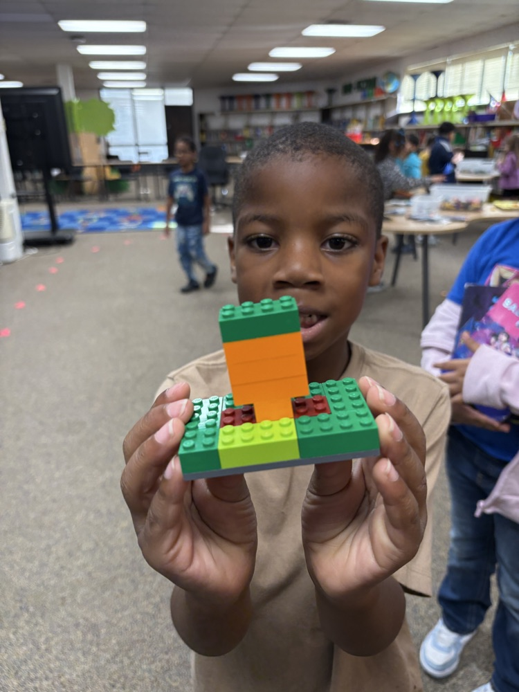 Student holding a Lego pumpkin 