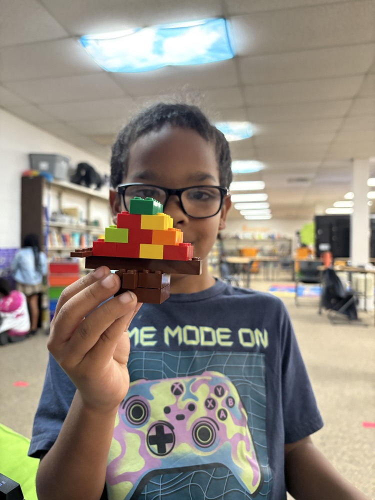 Student holding a Lego fall tree 