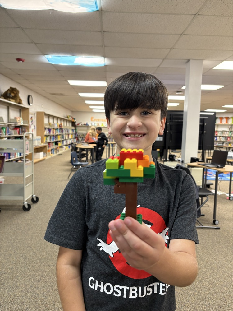 Student holding a Lego fall tree