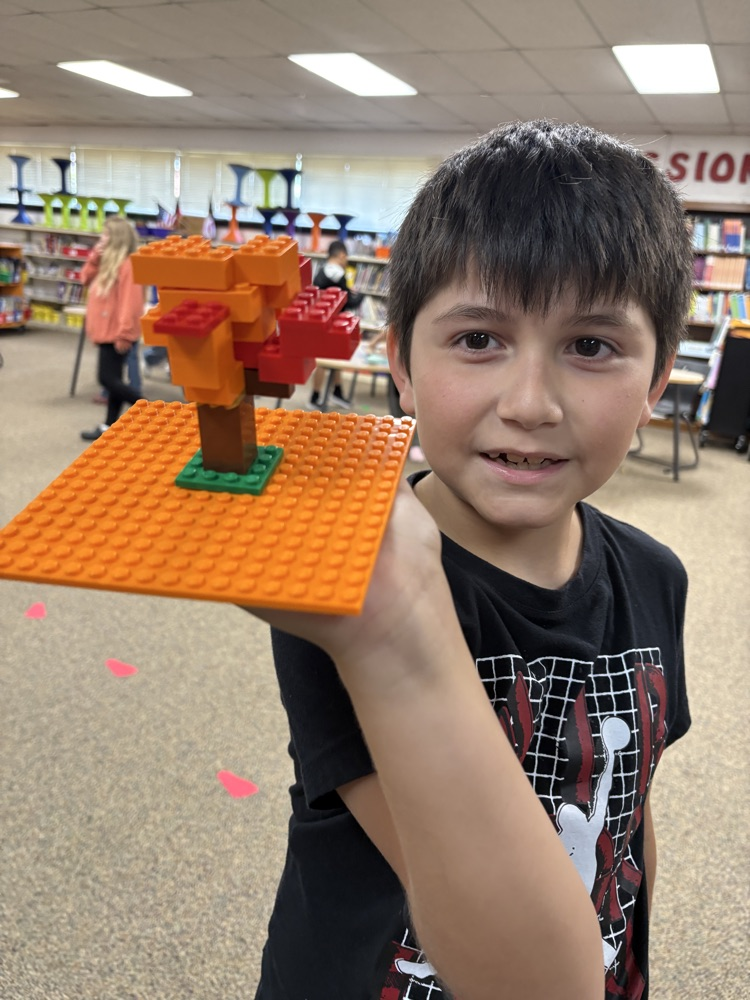 Student holding a Lego fall tree