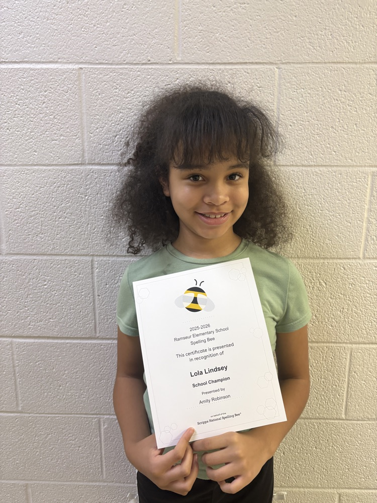 student holding certificate that says spelling bee champion