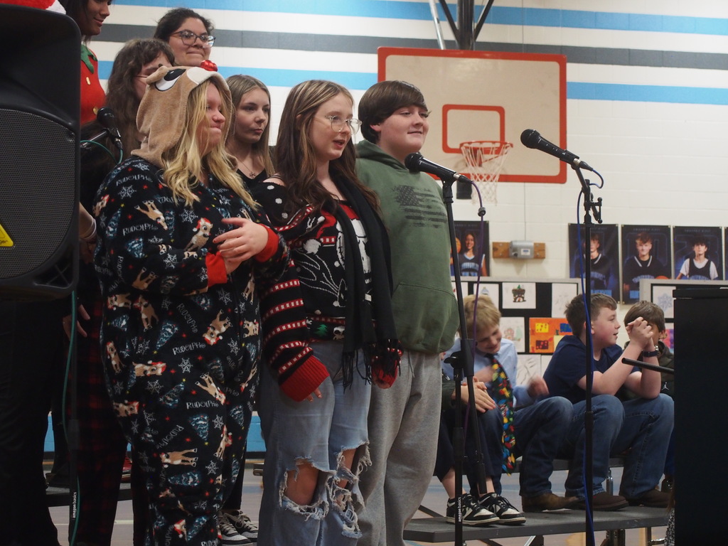 Students playing instruments and singing in a holiday band concert