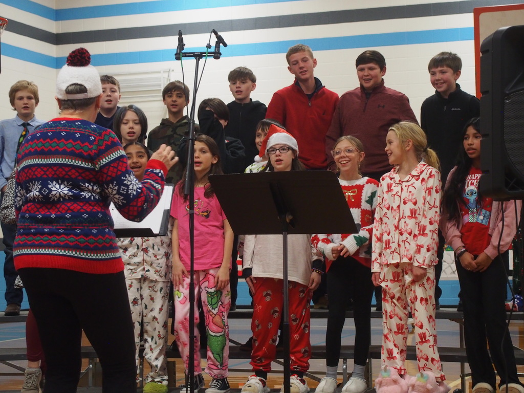 Students playing instruments and singing in a holiday band concert