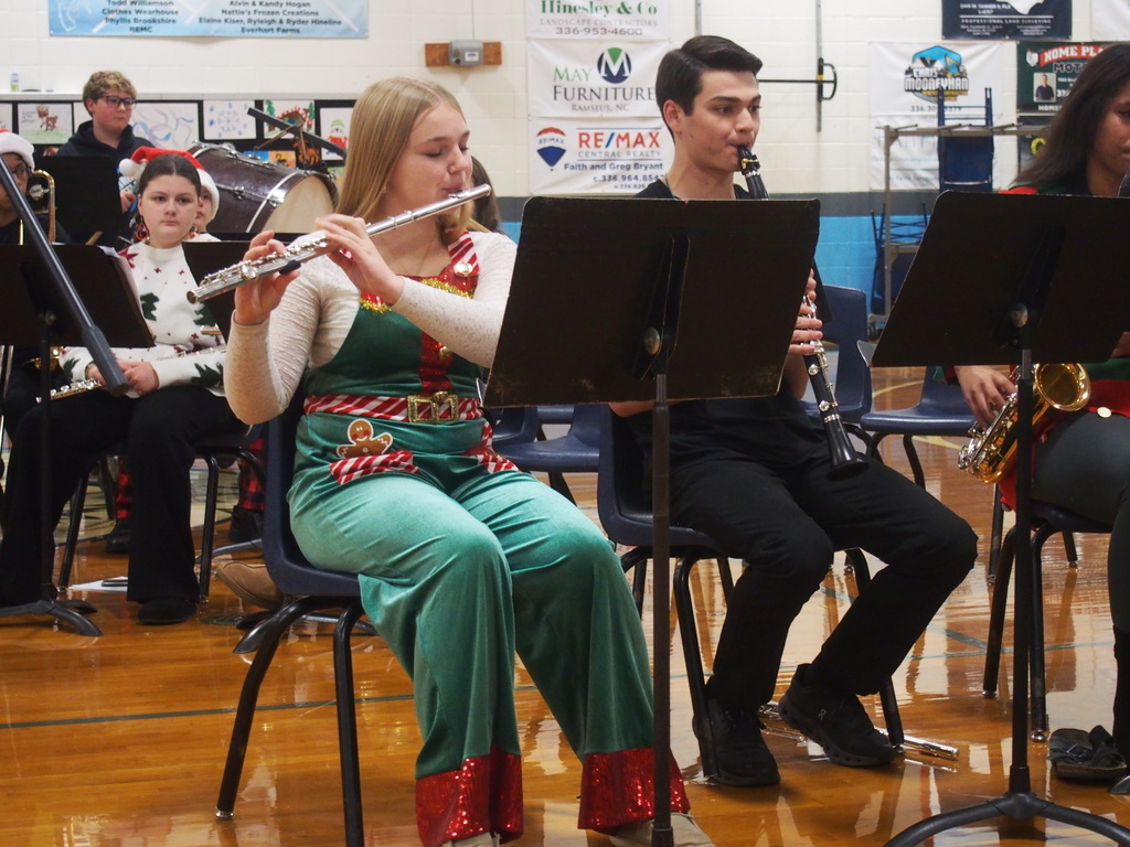 Students playing instruments and singing in a holiday band concert