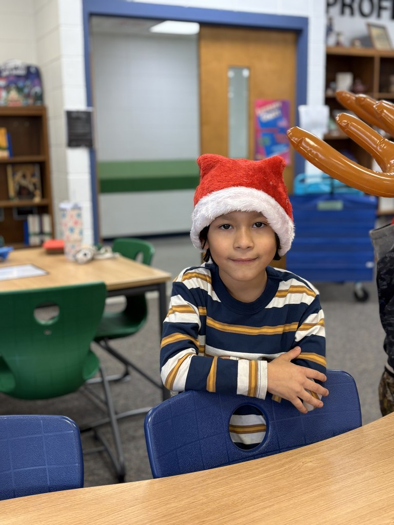 A student in the library wearing a Santa hat.