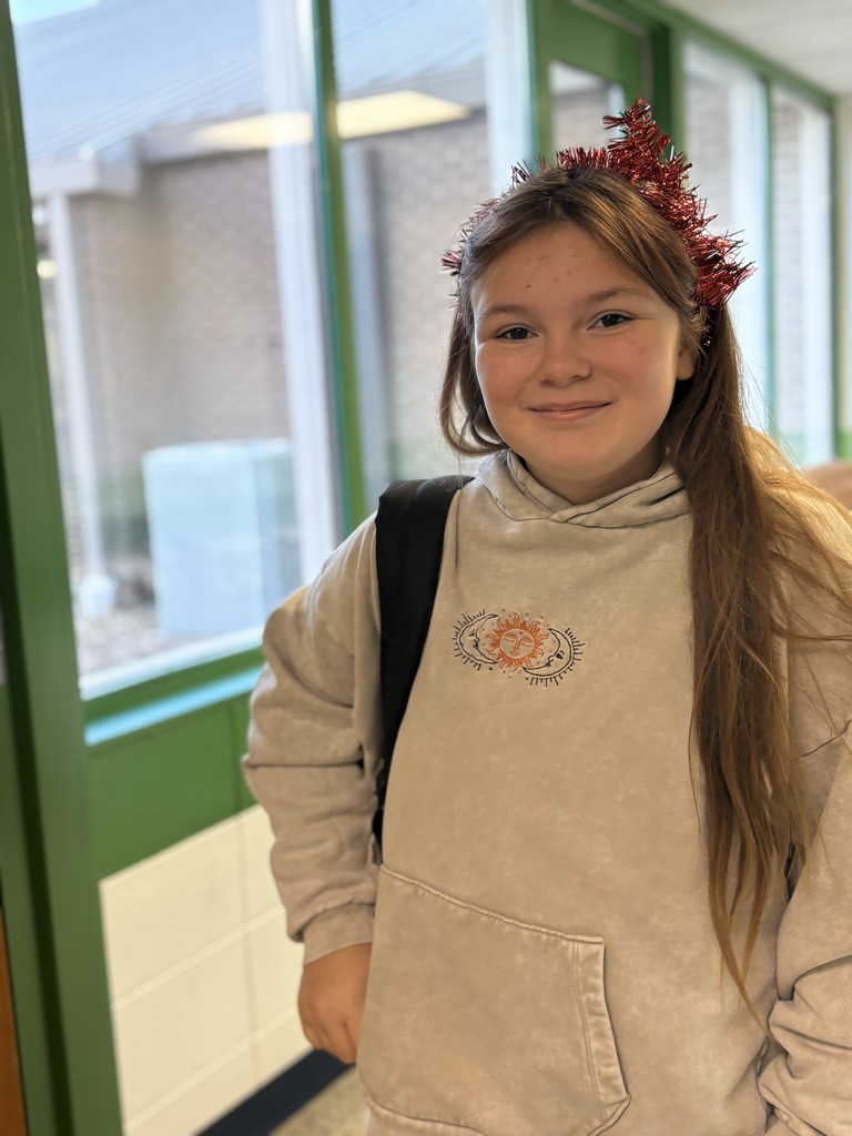 A student in the hallway with tinsel in her hair.