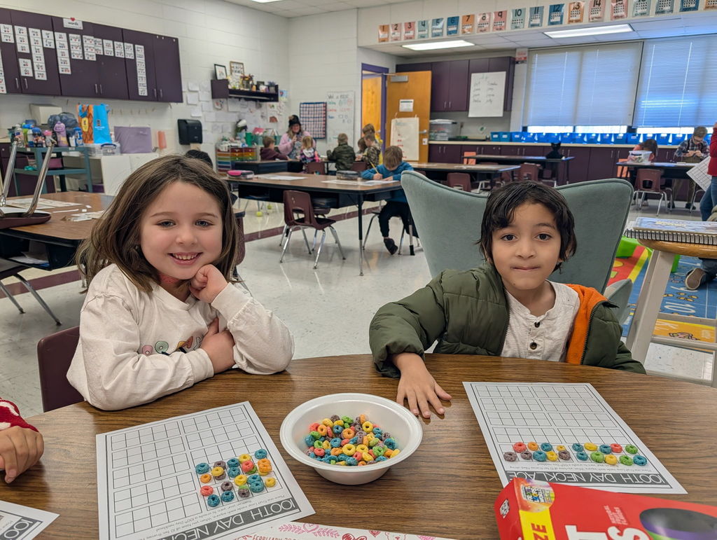 Two students working on 100th day of school activities in their classroom.