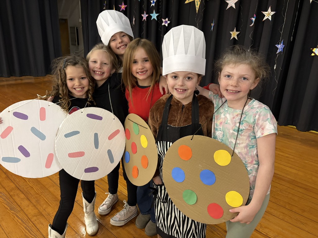 A group of girls wearing cookie outfits getting ready for their Science Night performance.