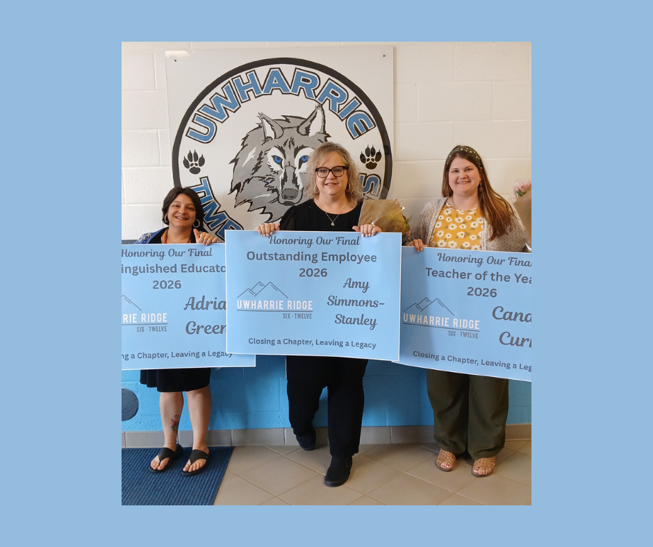 three teachers holding up signs in front of a picture of a wolf