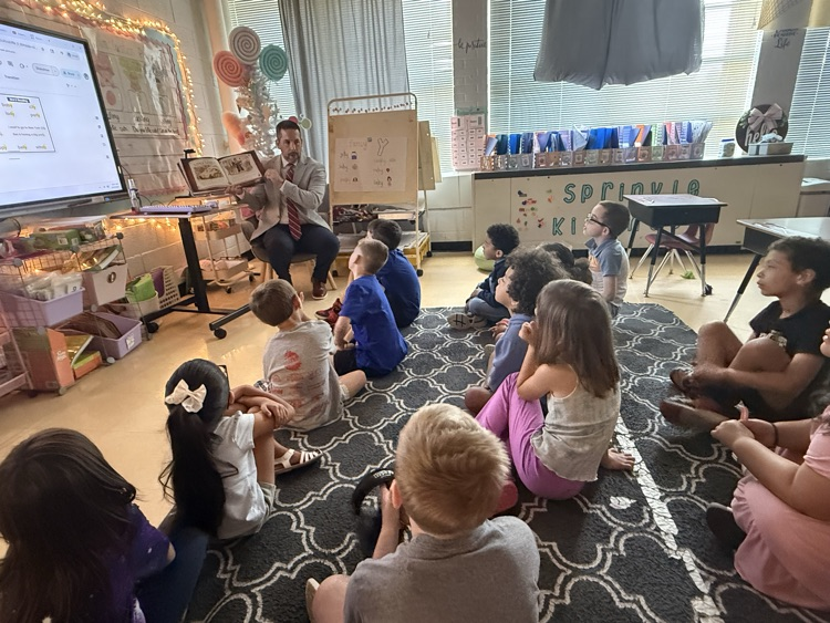 Mr. Grosch reading to Ms. Bowmans first grade clas