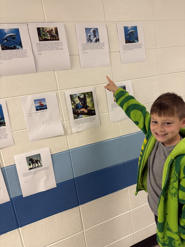 A student pointing to his work in the hallway.