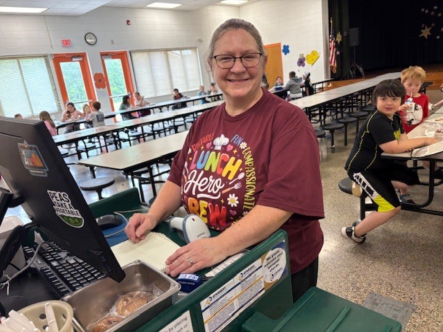 Ms. Alice helping check students out during lunch at Farmer