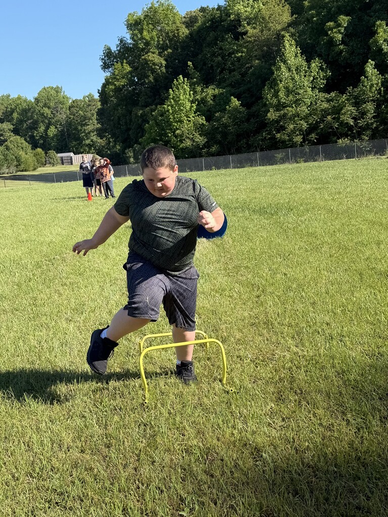 A student running over obstacles.