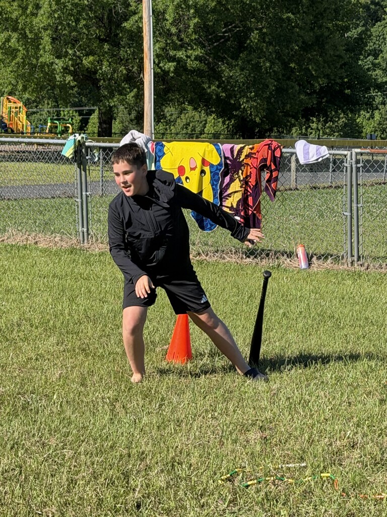 A student trying to run after spinning around a bat.
