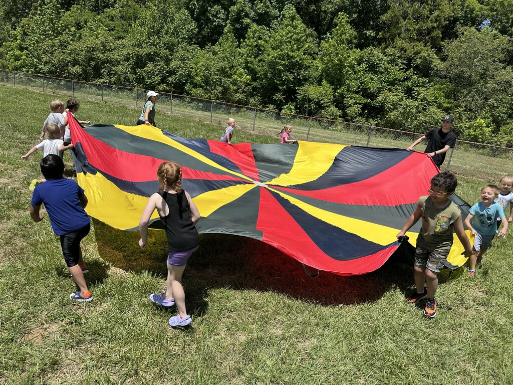 Students playing with a parachute during field day.