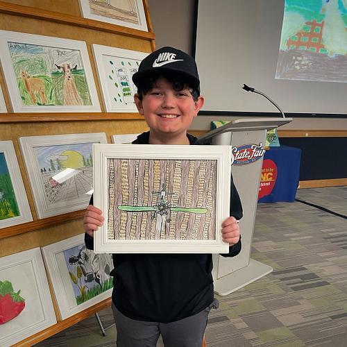 We are so proud to have another winner chosen for the NC Farm to School Calendar Contest! We celebrated Asher’s achievement in Raleigh on Friday at the State Fairgrounds during the Got To Be NC Festival. There were over 3,500 entries from 58 counties and only 13 were selected for the calendar. The calendar highlights the wonderful partnership between NC farms and school cafeterias. Way to go Asher!
