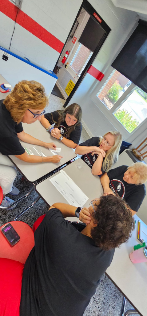 instructional Assistants and Reading Specialist working in a small group.
