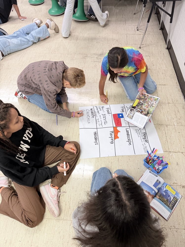 5th graders creating anchor charts for Hispanic Heritage Month