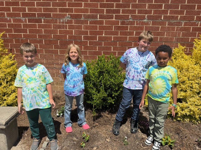 Second grade students posing on school grounds for Earth Day.