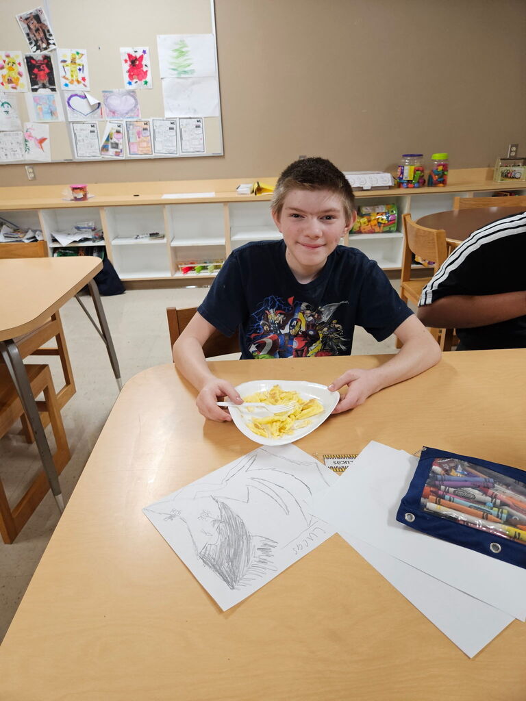 Student enjoying a plate of scrambled eggs