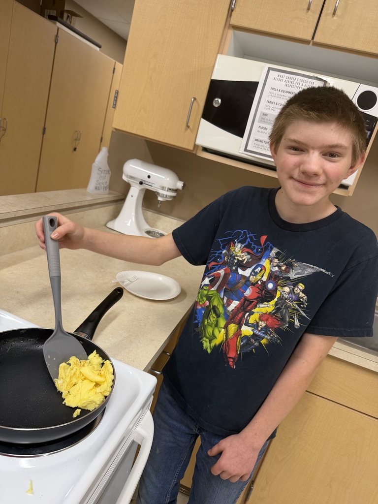 Young student cooking eggs on the stove