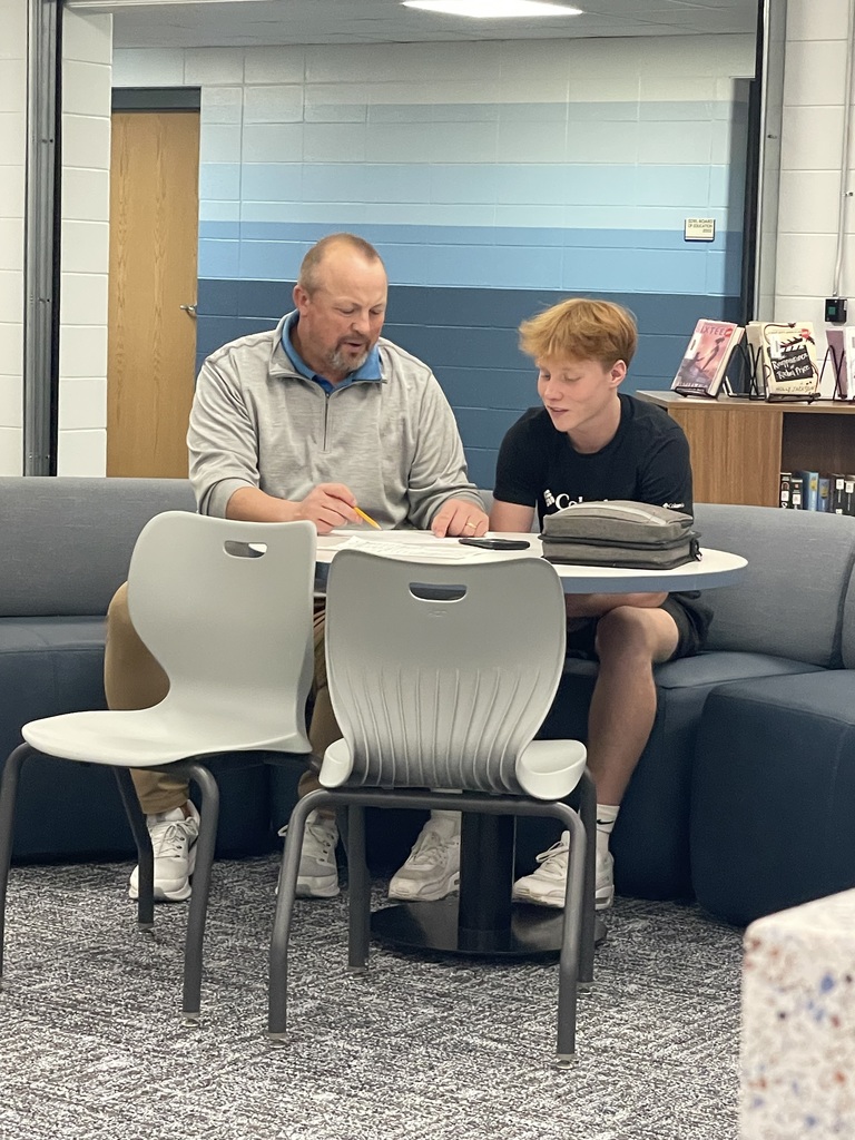 Mr. Jason Last looks over some math homework with one of his players