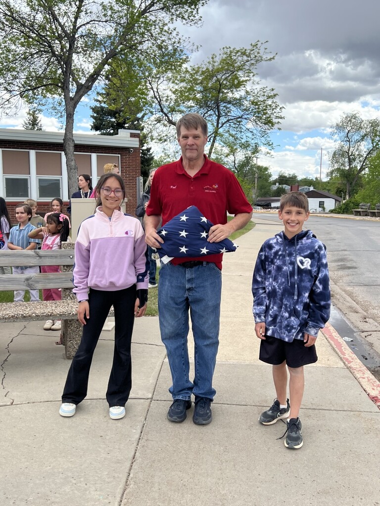 Adult and students with flag