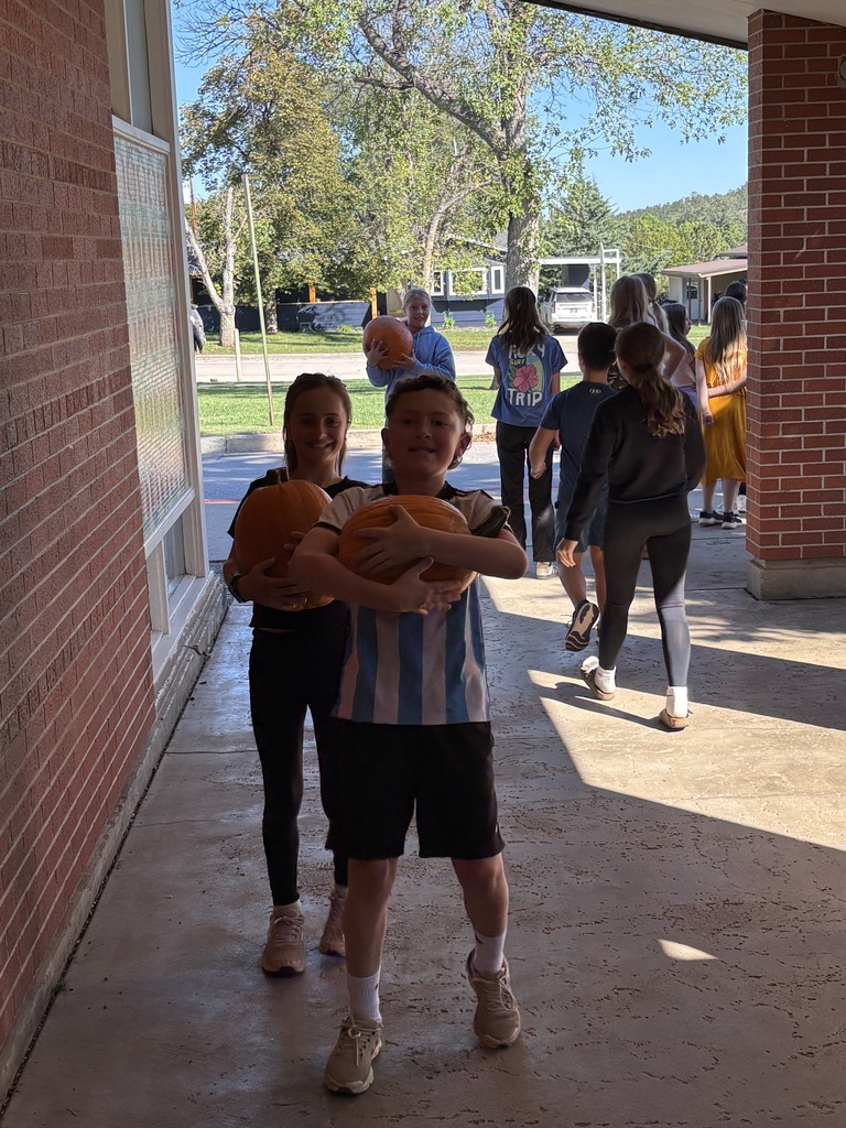 student carrying pumpkins