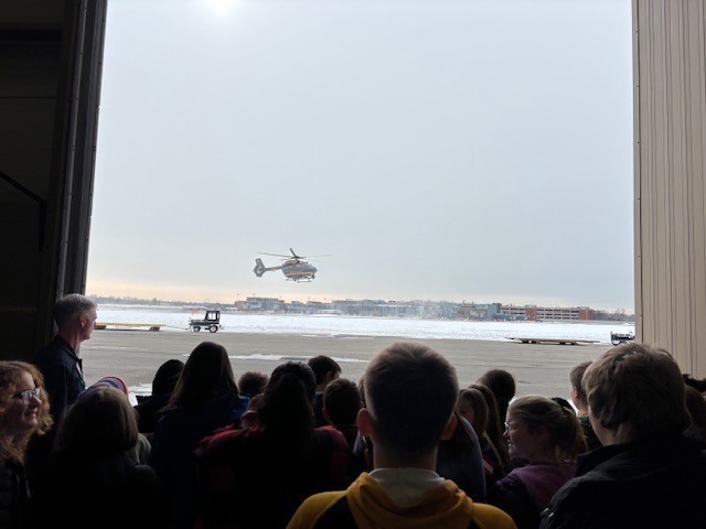 students watching a helicopter take off