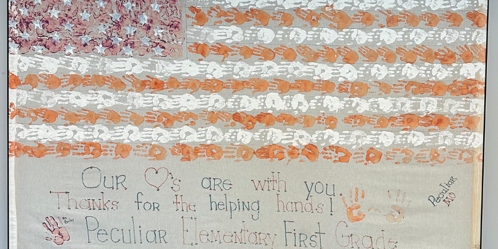 A hand painted banner of the American flag with children's signature.