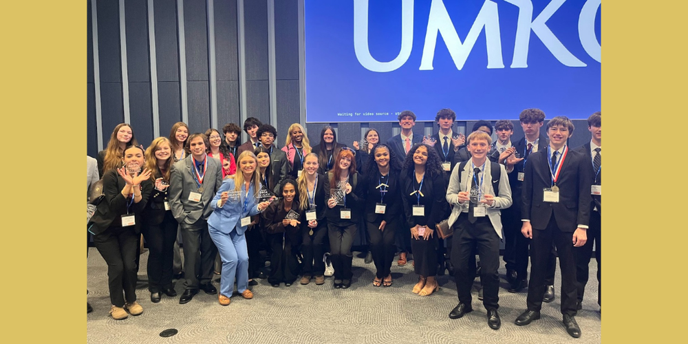 Group photo of marketing students holding awards at the DECA competition