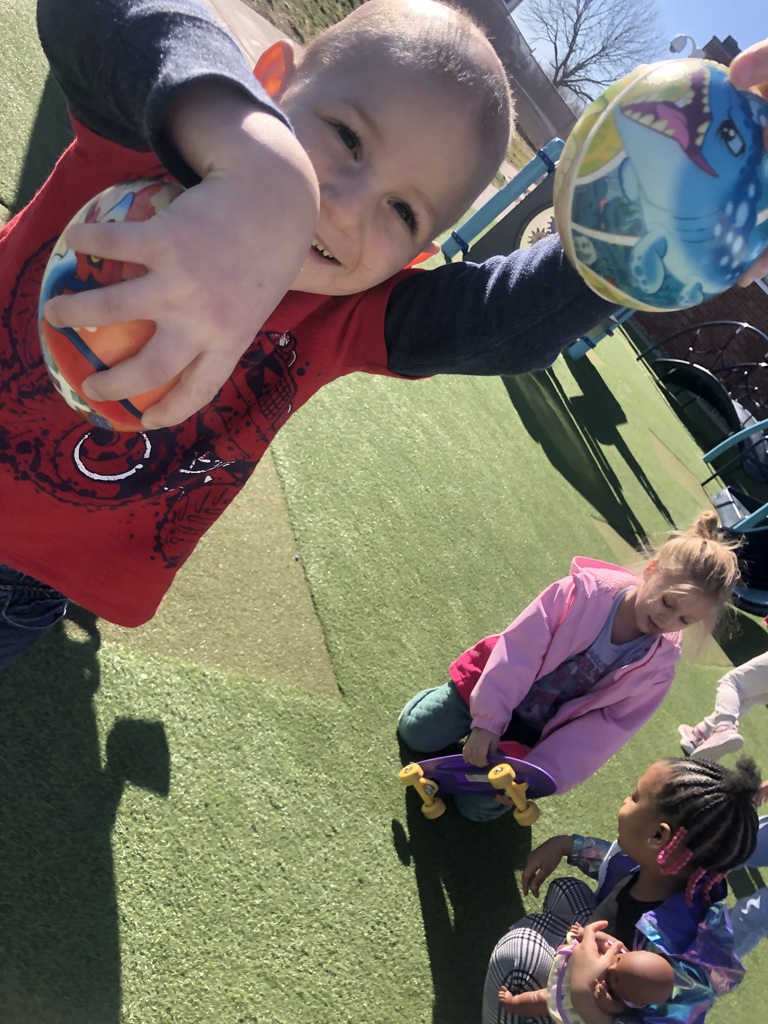 Children playing outside with toys.