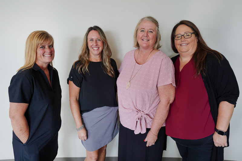 Four women standing together and smiling
