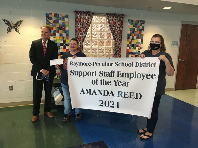 Three people with a banner for the 2021 Support Staff Employee of the Year