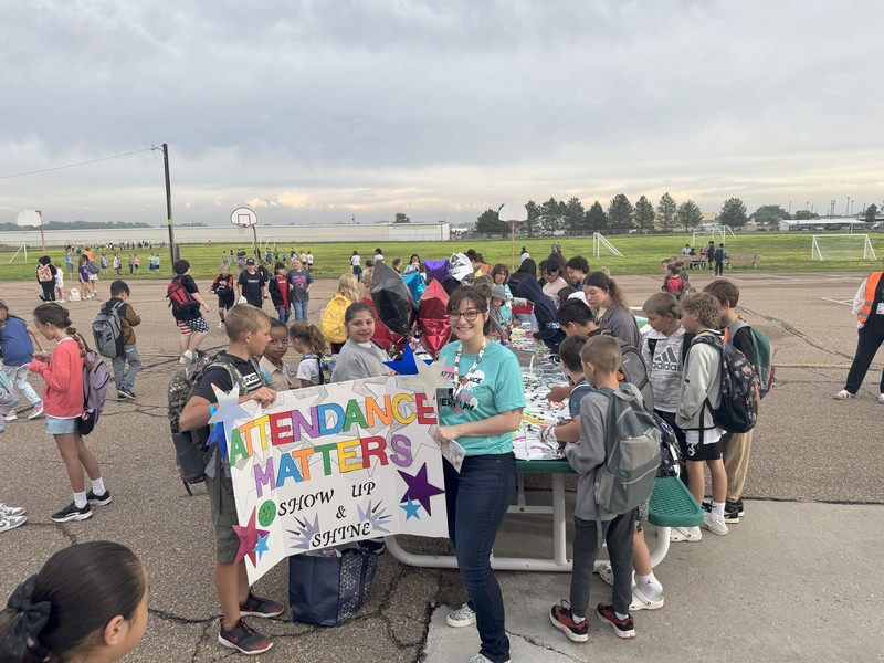students and adult holding poster