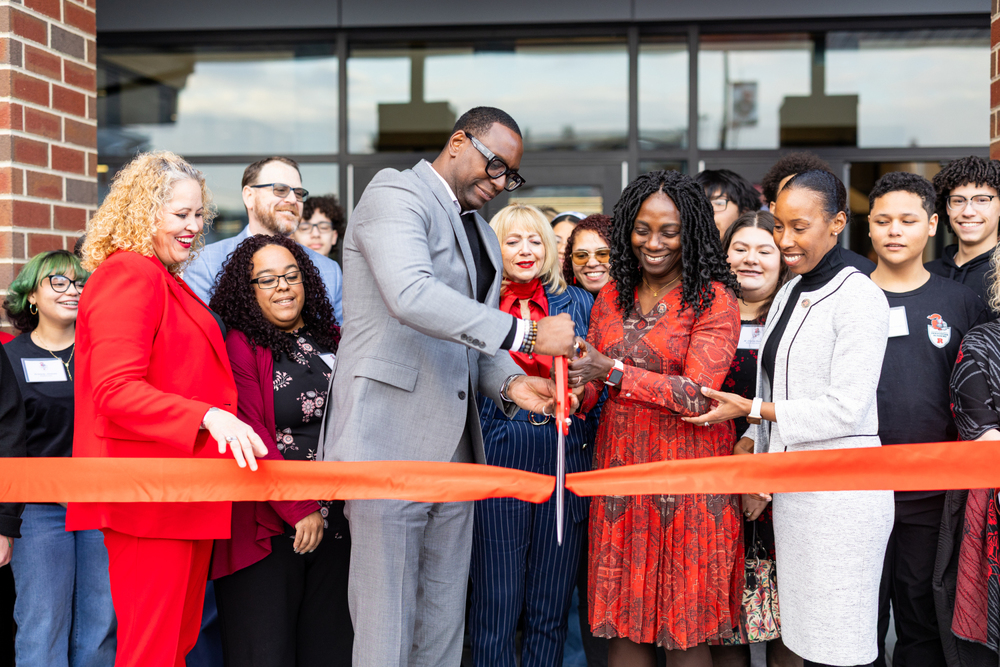 people gathered to cut the ribbon of a new building