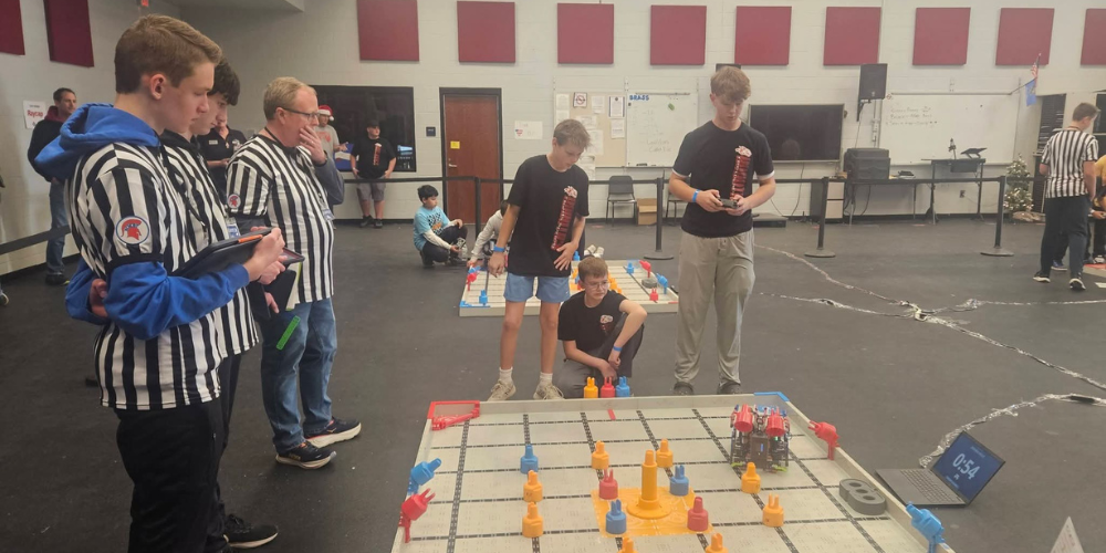 3 students controlling robot with remote control
