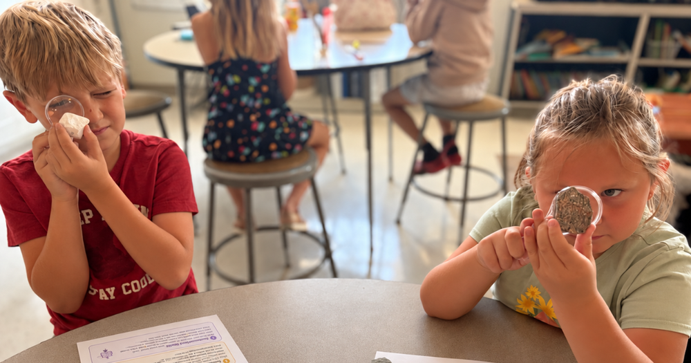 Two 2nd graders using magnifying glasses