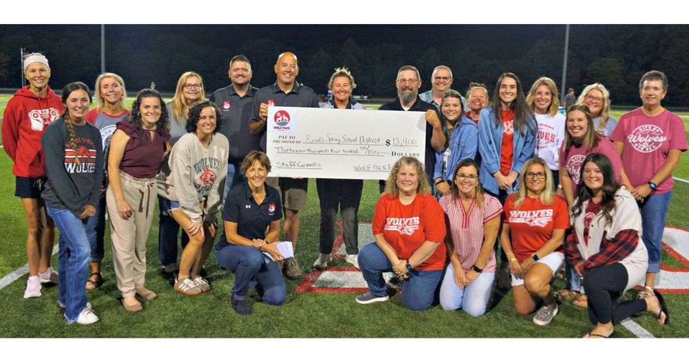 Teacher and Foundation members with a big check