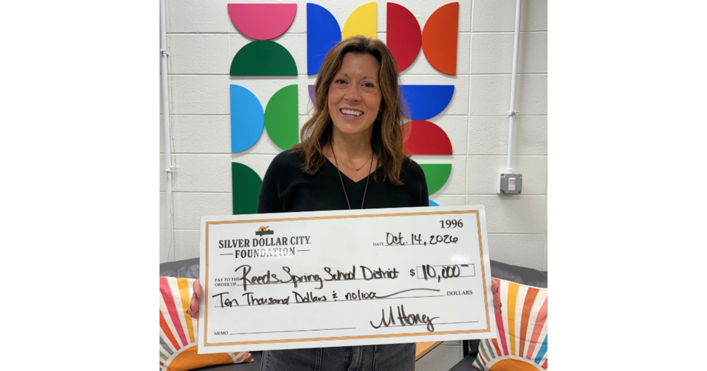 Adria Simkins holding a big check.