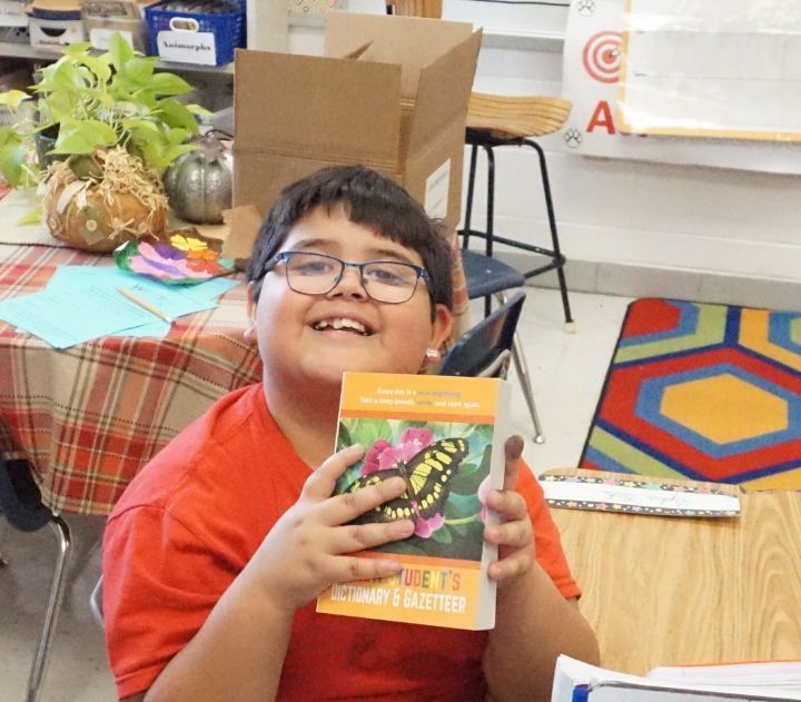 smiling boy holding book