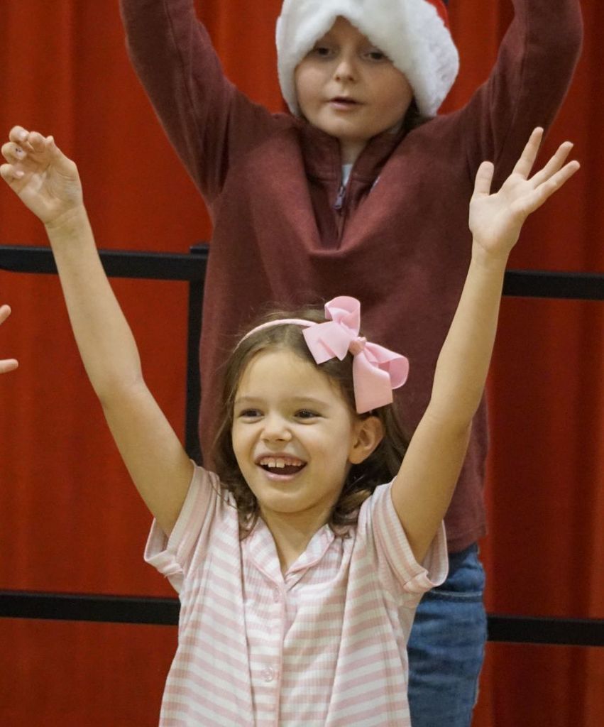 Charlie with huge smile and arms up