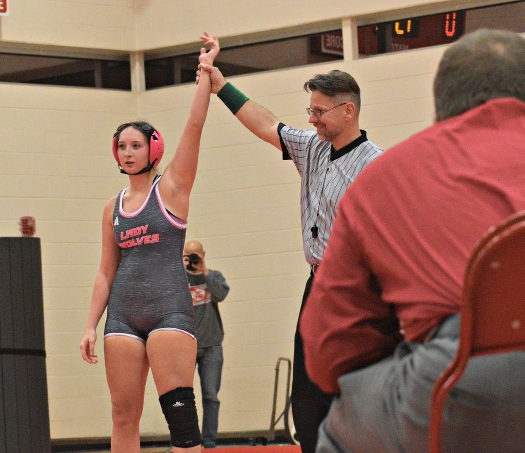 female wrestler armed raised in victory