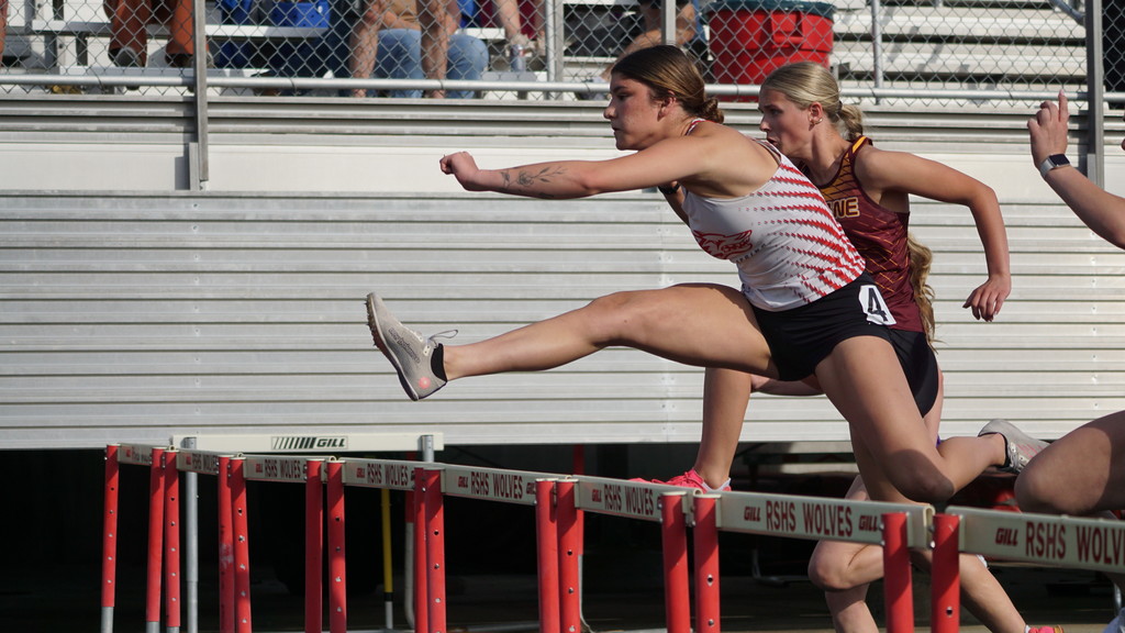 Emmarae Thompson jumping over hurdle