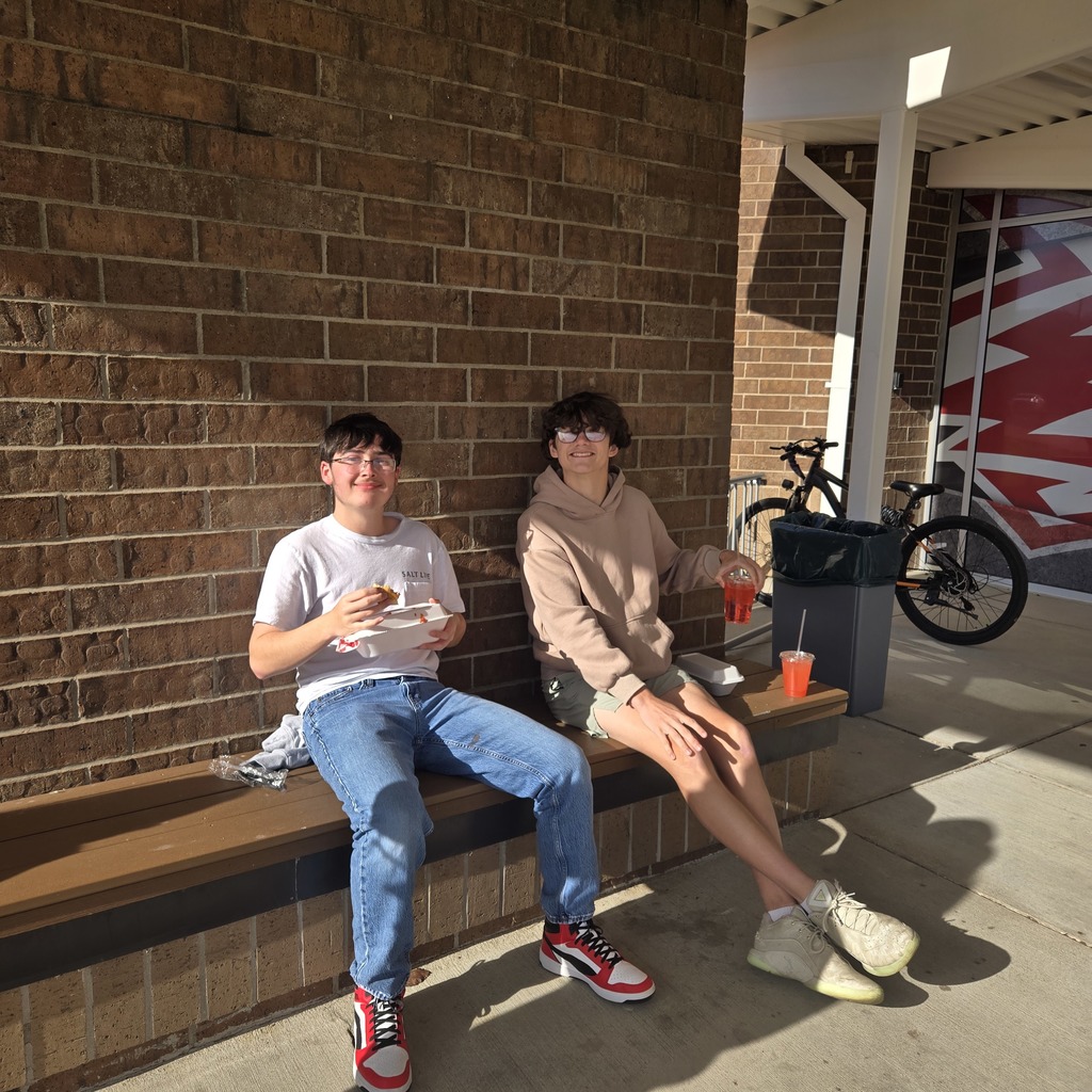 two boys sitting on a bench in front of RSHS