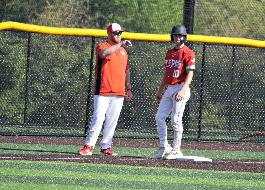 coach talking to runner on third