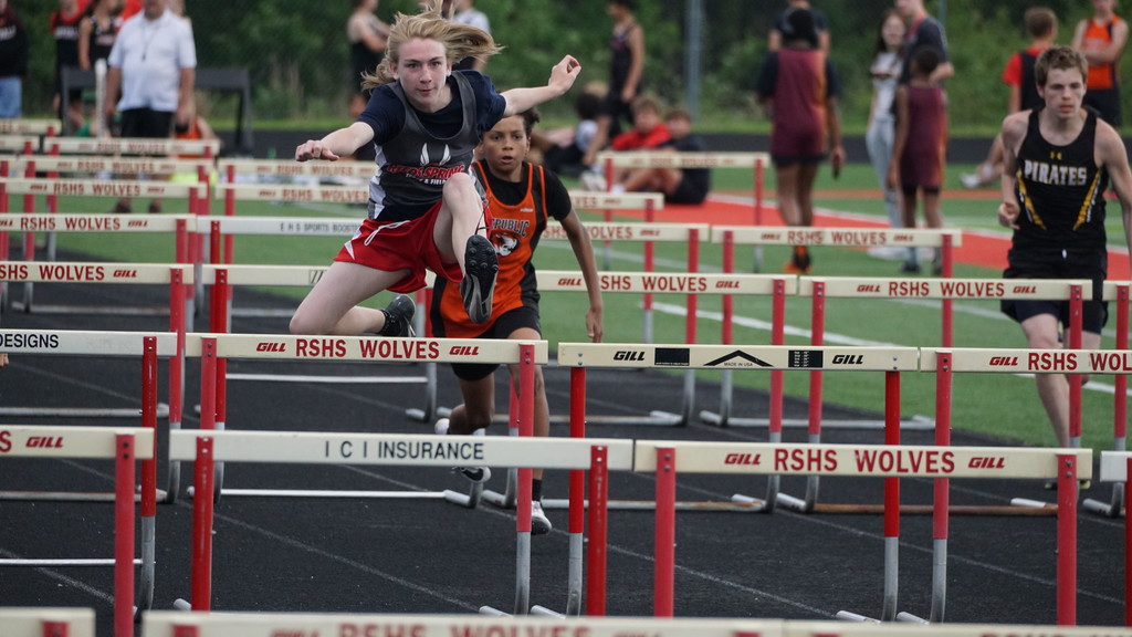 boy jumping over hurdle