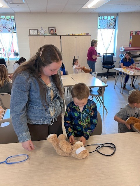 high school student works with Pre K student