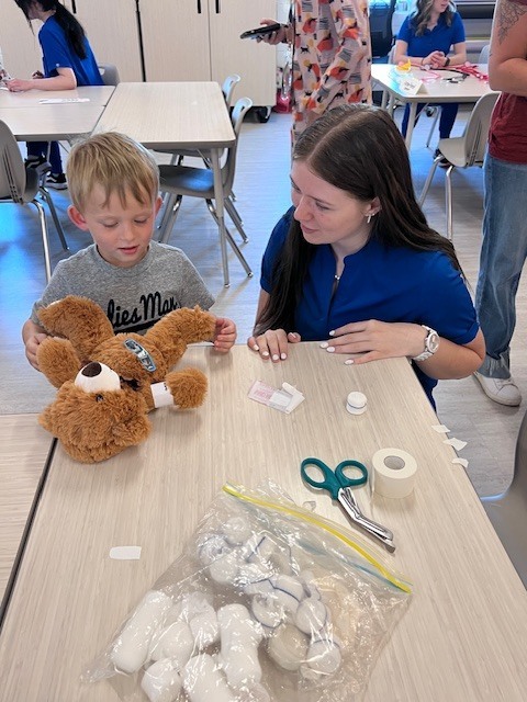 high school student works with Pre K student